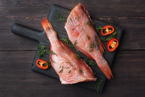 Raw fish perch without a head with lemon slices and dill greens and red chi.. Stock Photos