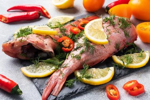 Raw fish perch without a head with lemon slices and dill greens and red hot.. Stock-Fotos