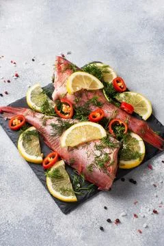 Raw fish perch without a head with lemon slices and dill greens and red hot.. Stock-Fotos