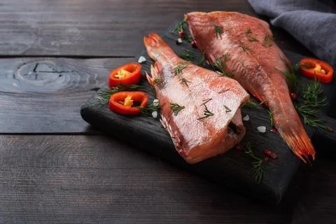 Raw fish perch without a head with lemon slices and dill greens and red chi.. Foto stock