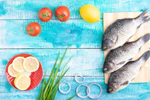 Raw fish, raw vegetables and lemon on wooden table,flat lay Stock Photos