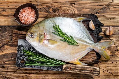 Raw fish Sunfish or pompano on a wooden board. wooden background. Top view Stock Photos