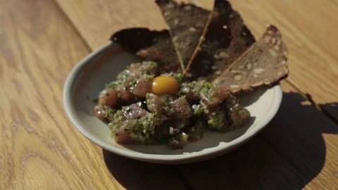 Raw Fish Tartare with Egg Yolk and Crispbread Served Outdoors in Sydney Stock Footage 345806035