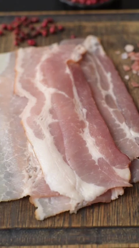 Raw fresh bacon slices with layers of meat or prosciutto with salt and spices. R Stock-Footage 335377642