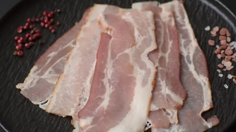 Raw fresh bacon slices with layers of meat or prosciutto with salt and spices. R Stock-Footage 335377656