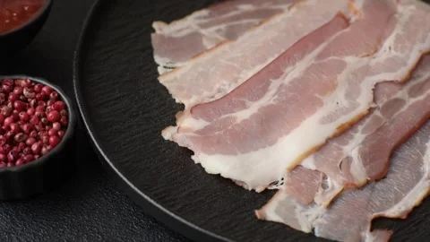 Raw fresh bacon slices with layers of meat or prosciutto with salt and spices. R Stock-Footage 335377659