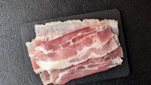Raw fresh bacon slices with layers of meat or prosciutto with salt and spices. R Stock-Footage 335377768