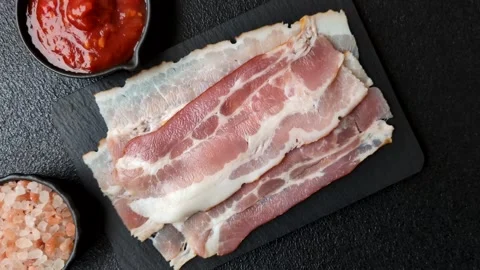 Raw fresh bacon slices with layers of meat or prosciutto with salt and spices Stock-Footage 335377828
