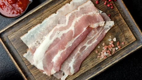 Raw fresh bacon slices with layers of meat or prosciutto with salt and spices Stock-Footage 335377850
