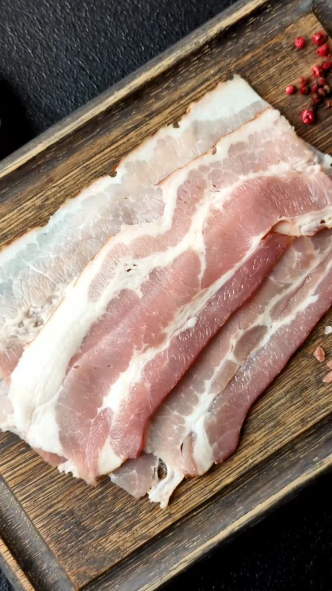 Raw fresh bacon slices with layers of meat or prosciutto with salt and spices Stock-Footage 335377875