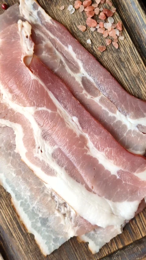 Raw fresh bacon slices with layers of meat or prosciutto with salt and spices Stock-Footage 335377889