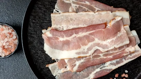 Raw fresh bacon slices with layers of meat or prosciutto with salt and spices Stock-Footage 335377903