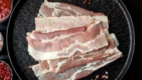 Raw fresh bacon slices with layers of meat or prosciutto with salt and spices Stock-Footage 335377910