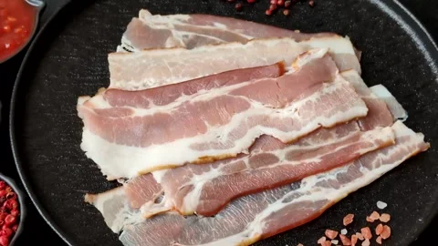Raw fresh bacon slices with layers of meat or prosciutto with salt and spices Stock-Footage 335377912