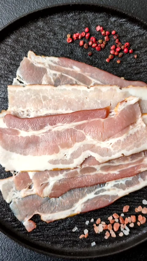 Raw fresh bacon slices with layers of meat or prosciutto with salt and spices Stock-Footage 335377918