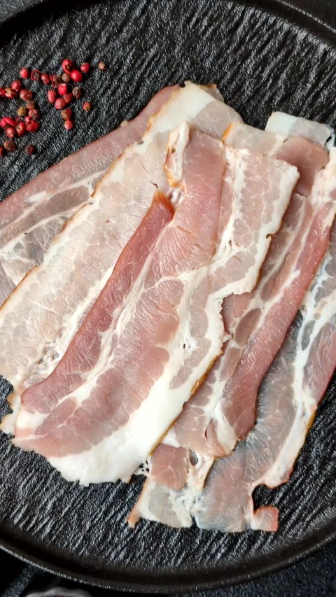 Raw fresh bacon slices with layers of meat or prosciutto with salt and spices Stock-Footage 335377924