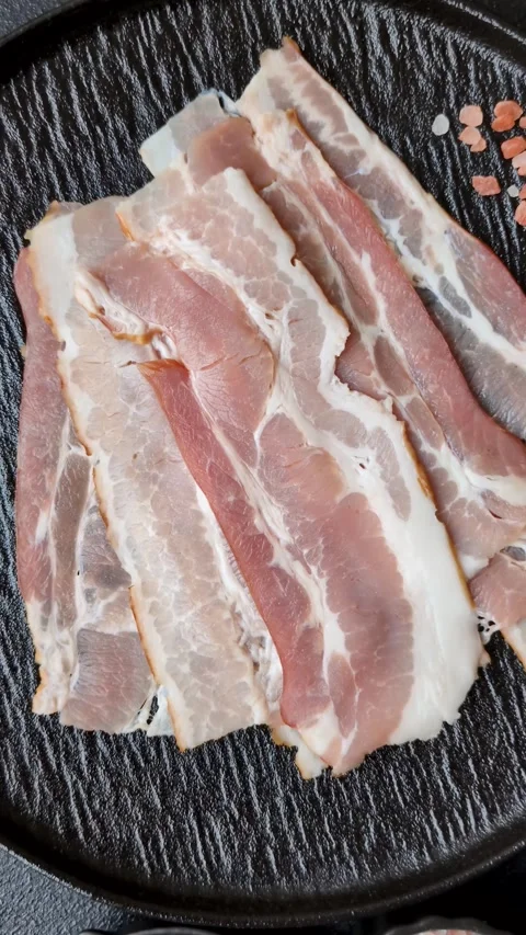 Raw fresh bacon slices with layers of meat or prosciutto with salt and spices Stock-Footage 335377926
