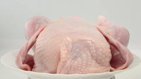 Raw fresh chicken is being turned on a spit. Cooking chicken Stock Footage 274450903