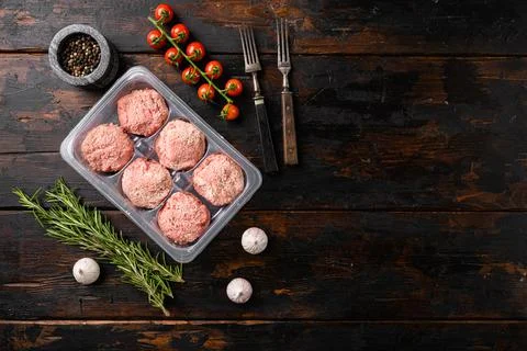 Raw fresh chicken cutlets in plastic transparent container, on old dark wooden Stock Photos