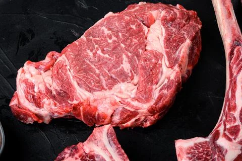 Raw fresh marbled meat Steak Ribeye. Black Angus Rib eye, on black stone back Foto stock