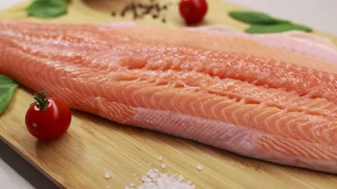 Raw, fresh salmon steak on a cutting board and spices around Raw salmon red fish Stock Footage 221264545