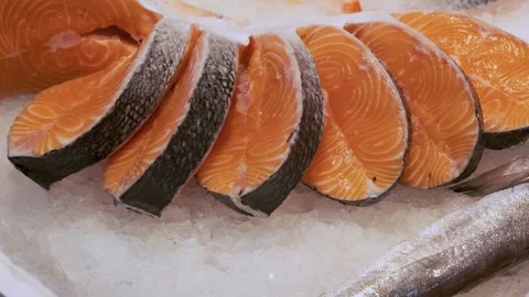 Raw fresh salmon steaks lying on ice counter at seafood market in Athens, Greece Stock Footage 258231539