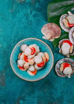 Raw fresh seafood shellfish scallops on blue background Raw fresh seafood ... Stock Photos