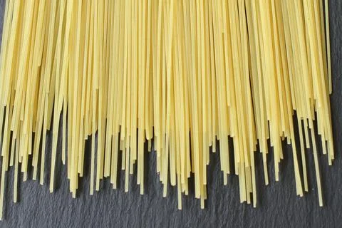 Raw fresh spaghetti thin yellow on black background Stock Photos