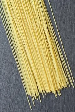 Raw fresh spaghetti thin yellow on black background Stock Photos
