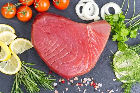 Raw fresh tuna slice in the kitchen and decorates with herbs and citruse Stock Photos