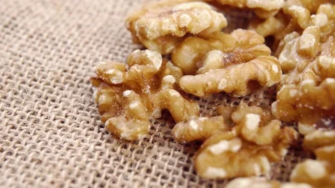 Raw fresh walnut kernels on a rough rustic cloth. Macro Stock Footage 165593596