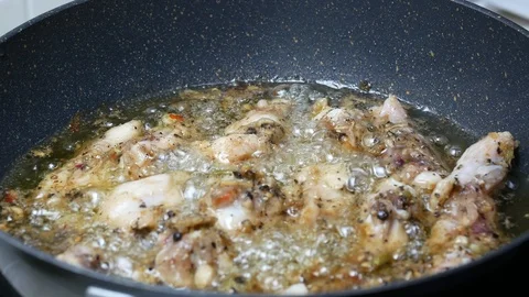Raw fried leg chicken  boiled food palm oil in black teflon induction pan Stock-Footage 89513716