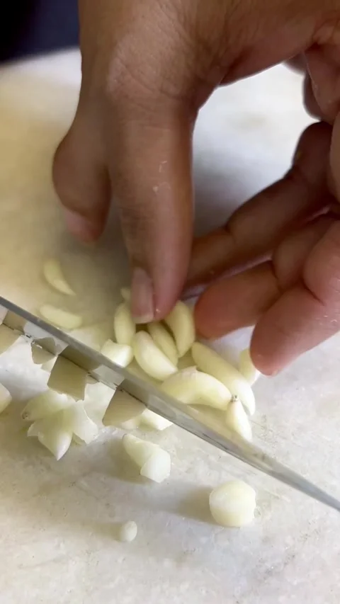 Raw garlic cutting on a stone chopping board Stock Footage 287436852