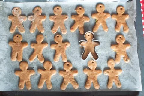 Raw gingerbread men on a baking Stock Photos