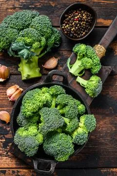 Raw green broccoli cabbage in a colander. Dark wooden background. Top view Stock Photos