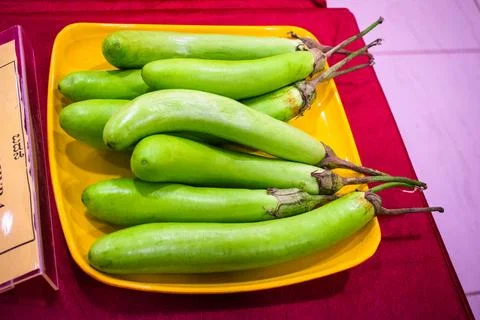 Raw green eggplants on a plate. Stock Photos