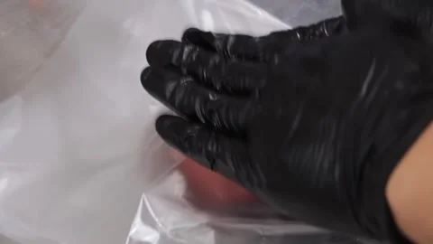 Raw ground beef ball sits in a small metal container wrapped in clear plastic re Stock Footage 331632919