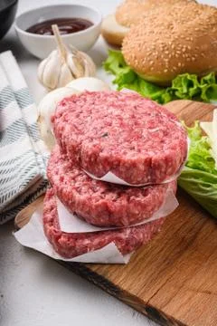 Raw ground beef meat cutlets for burger on white textured background Stock Photos