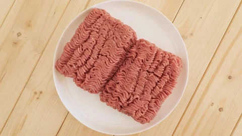 Raw ground meat rotating on a white plate Stock Footage 337011645