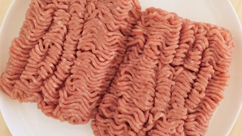 Raw ground meat rotating on a white plate Stock Footage 337441287