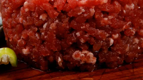 Raw hamburger cutlet with sprouts and chili pepper on wooden plate over black Vídeos de archivo 36771216