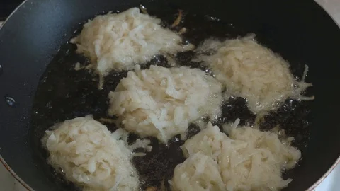 Raw hash browns fried in a pan in oil Stock Footage 108006822