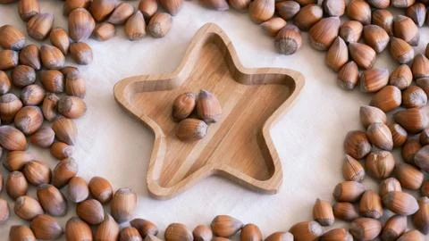 Raw hazelnuts on bamboo star shape plate Stock Photos