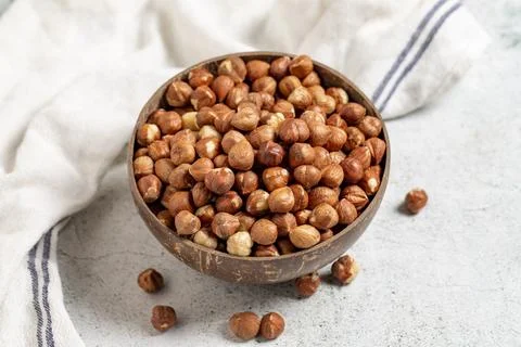 Raw hazelnuts on a gray background. Nuts in a coconut bowl. close up Stock Photos