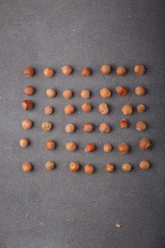 Raw hazelnuts in shells lay out in square shape on grey background Stock Photos