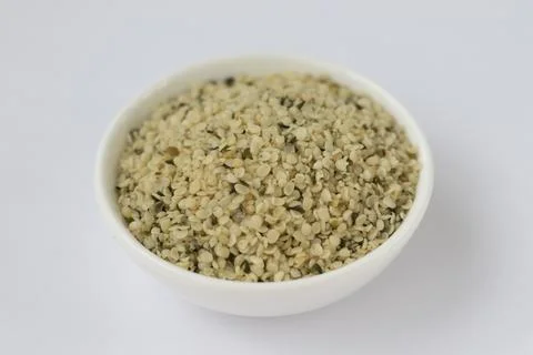 Raw hemp kernels in a small plate on a white background. Omega 3 Stock Photos