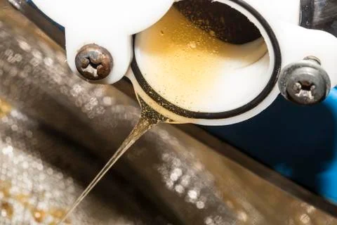 Raw honey go down from a container for the processing Stock Photos