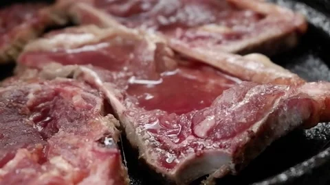 Raw juicy beef being cooked on an iron plate Stock Footage 142022546