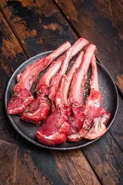 Raw lamb chop cutlets, fresh mutton meat for steaks with herbs. wooden back.. Stock Photos