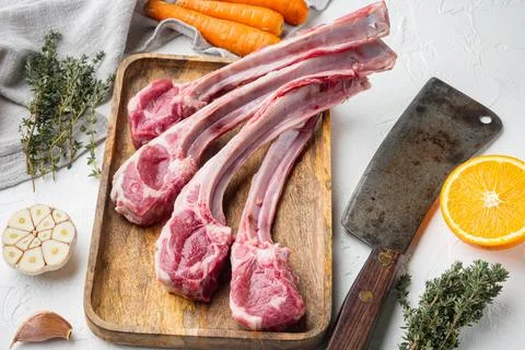 Raw lamb chops or mutton cuts, with ingredients carrot orange, herbs, and old Stock Photos